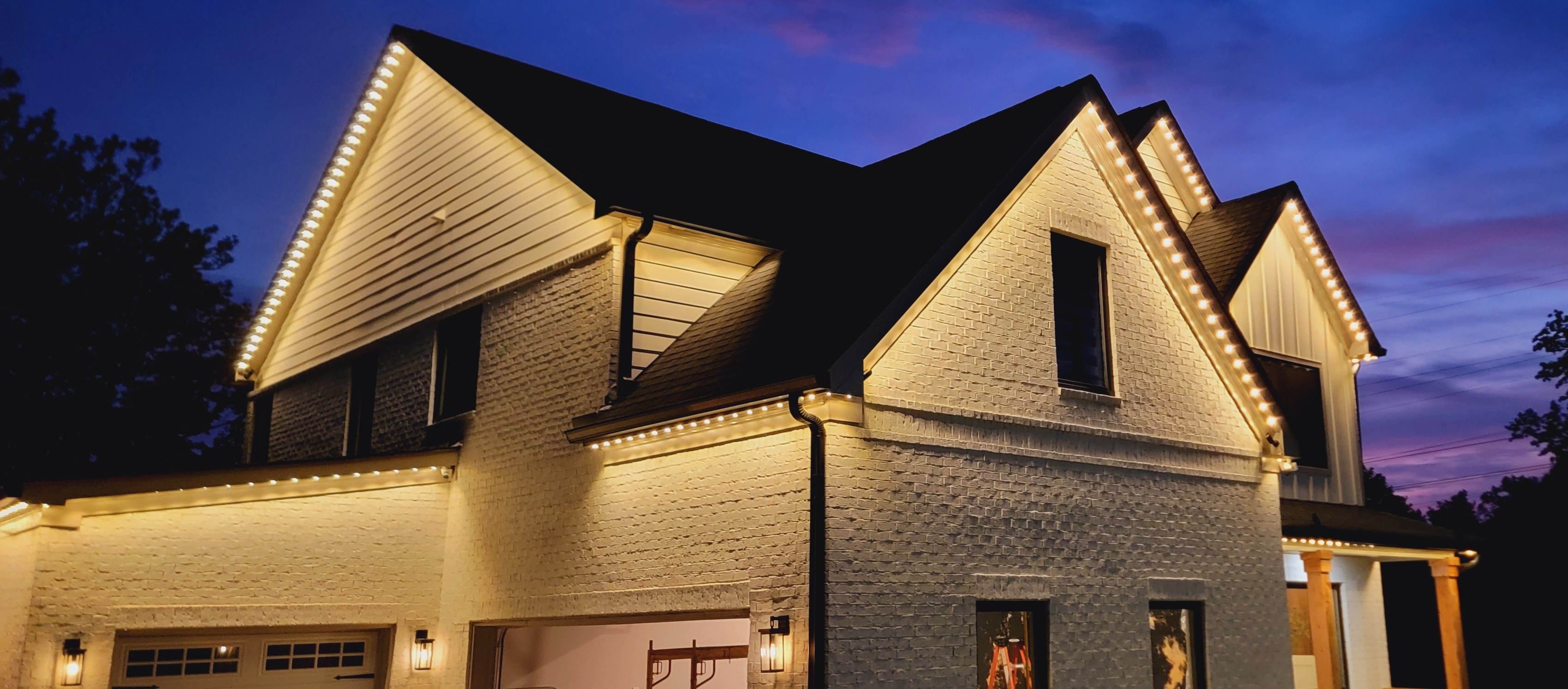 Home with elegant warm white permanent roofline lighting